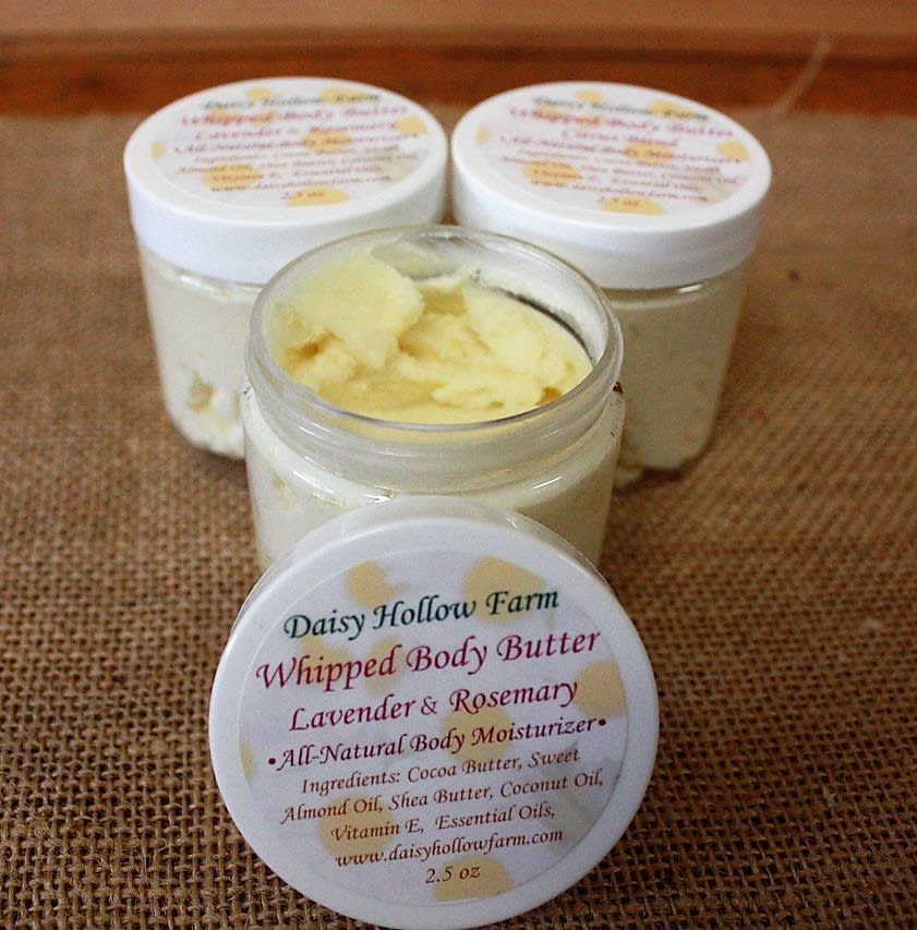 Three jars of whipped body butter on burlap, one open in front