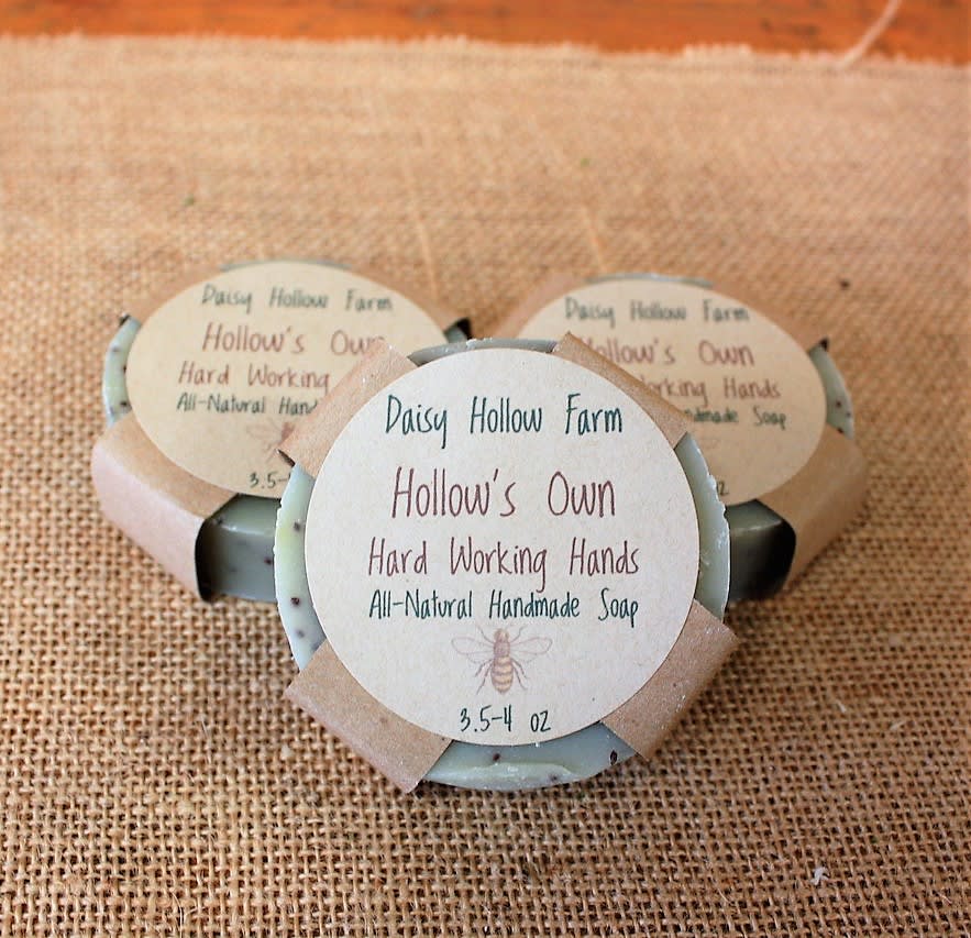 Three bars of handmade soap with paper labels on burlap