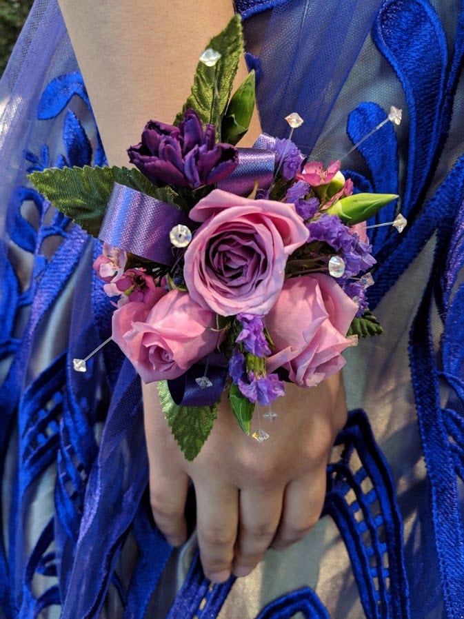 Purple and pink wrist corsage with roses and ribbon