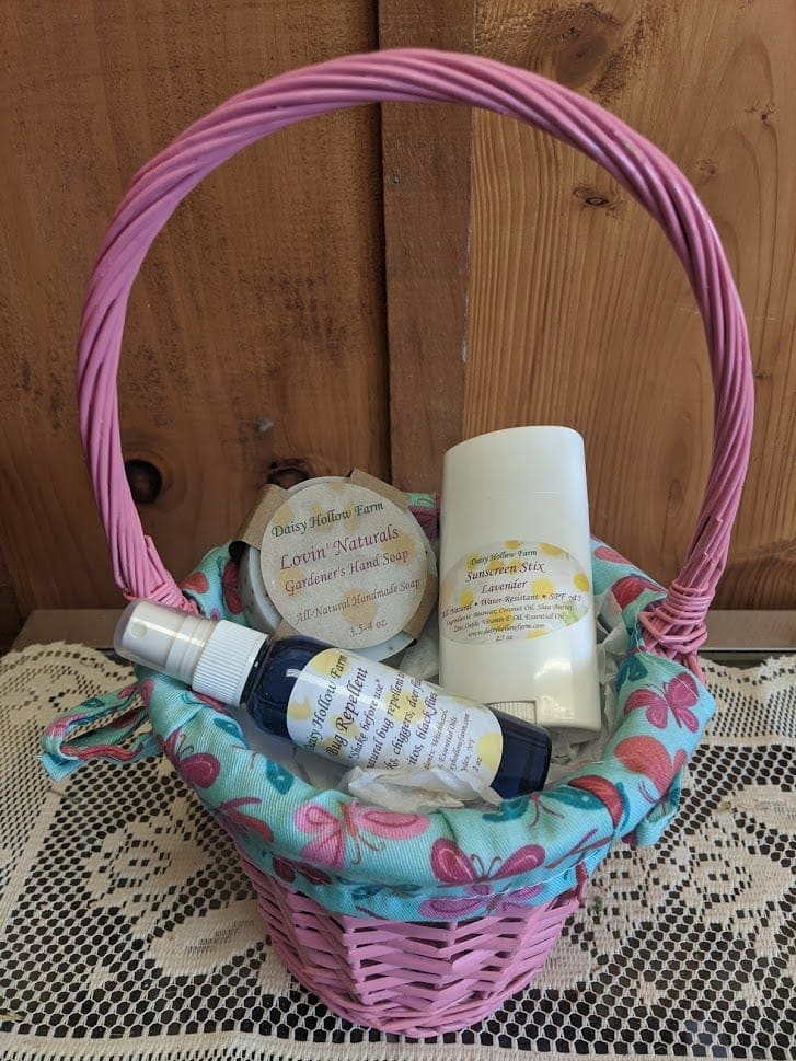 Pink wicker basket with soap and spray bottles on a table