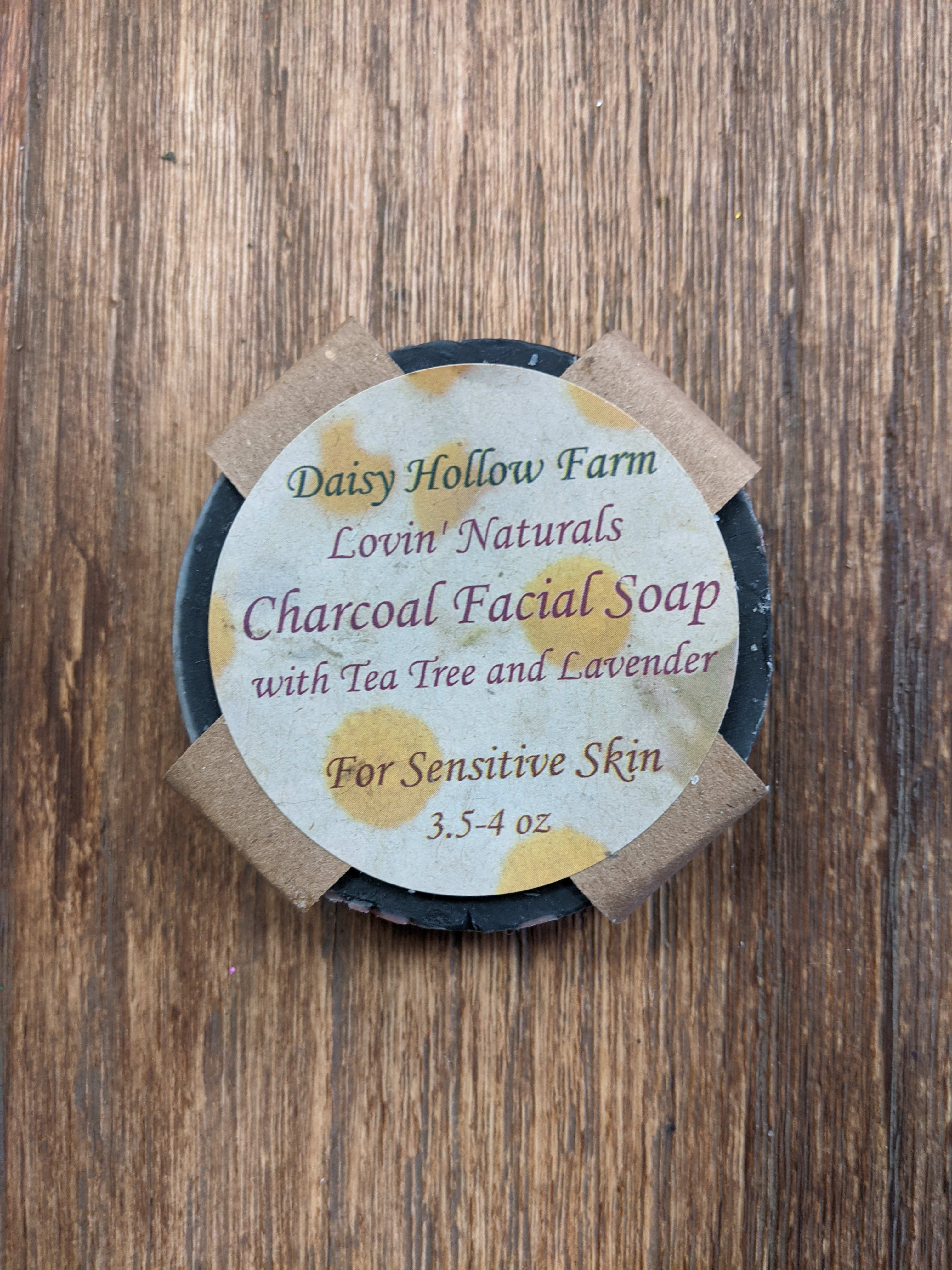 Round charcoal facial soap bar with a labeled paper top