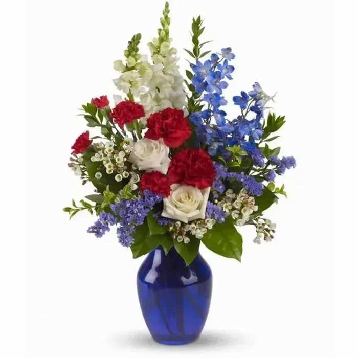 Red, white, and blue flower arrangement in a cobalt vase