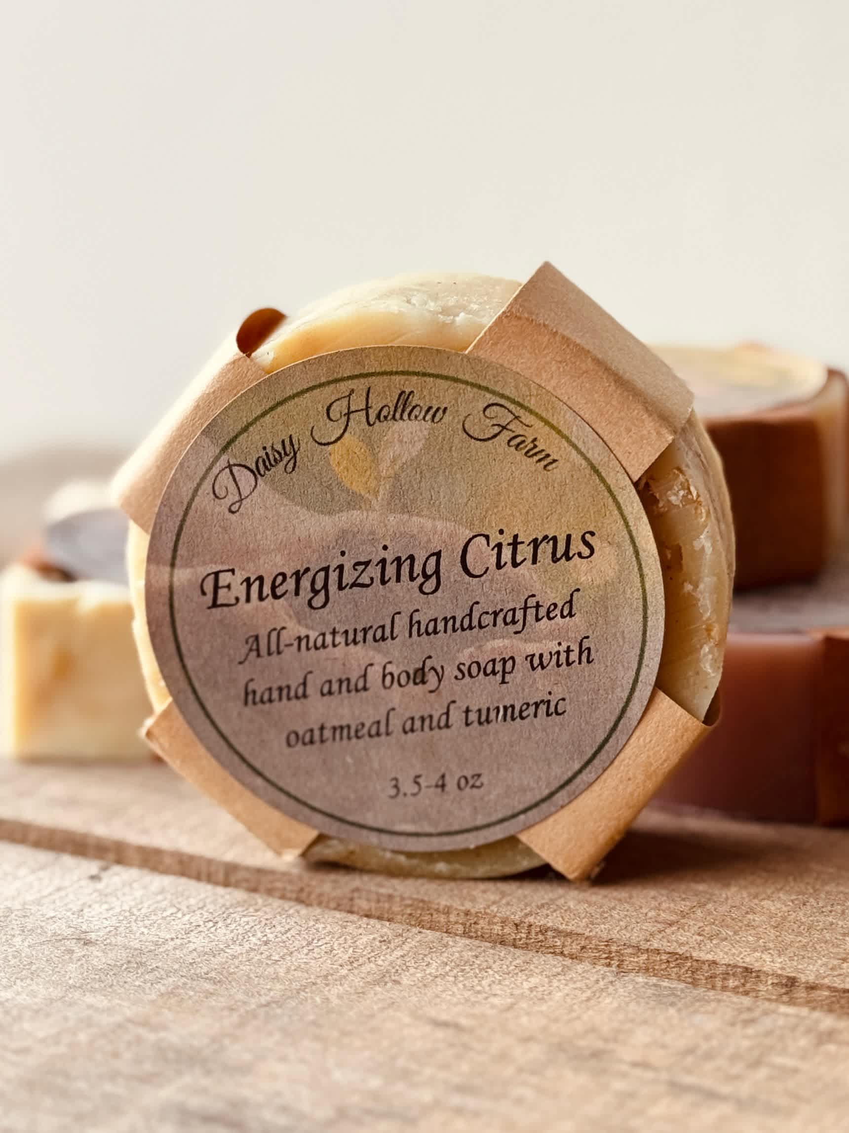Round citrus soap bar with a paper label on a wooden surface