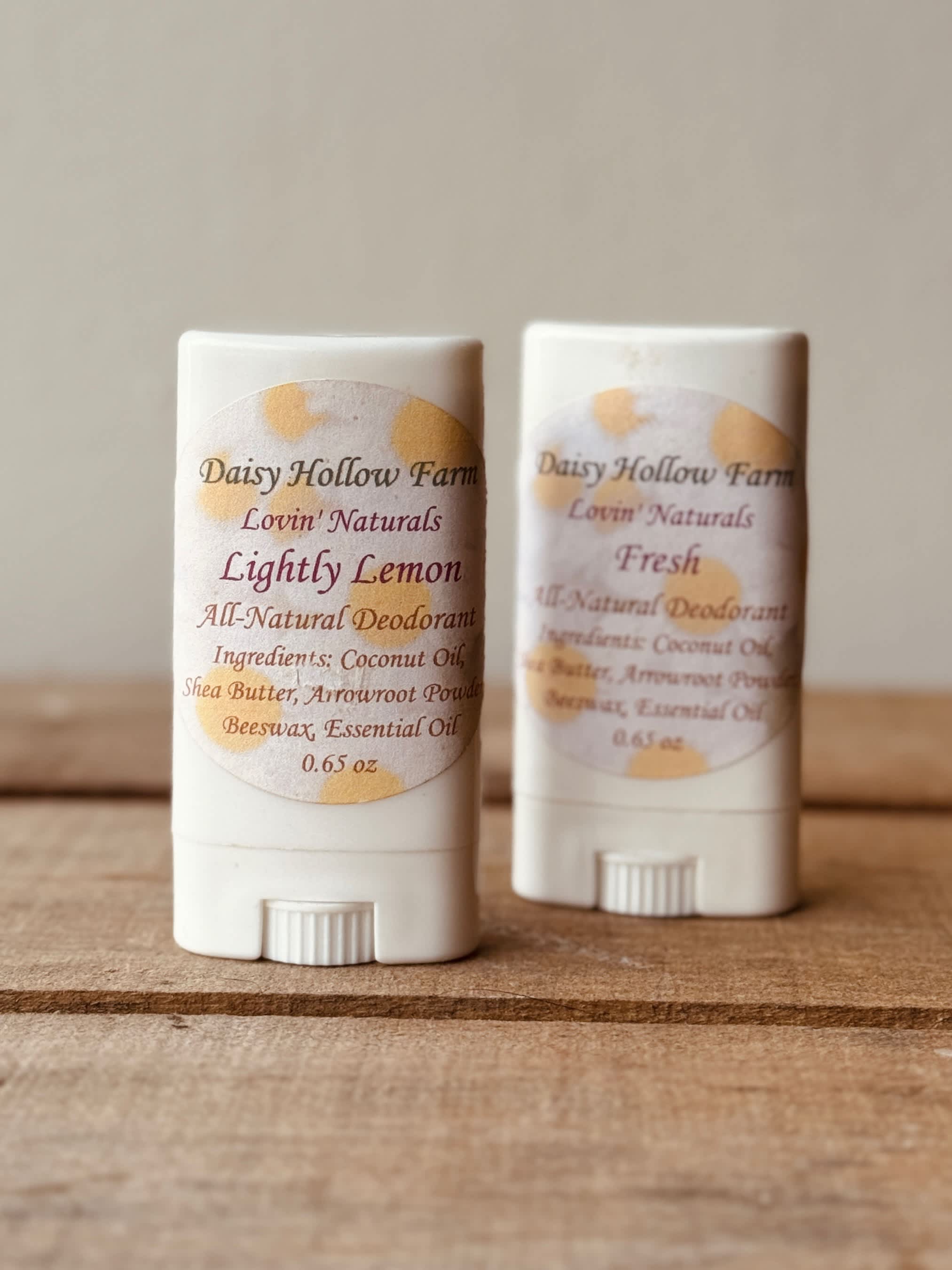 Two natural deodorant sticks on a wooden surface