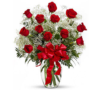 Red roses in a clear glass vase with a red ribbon bow