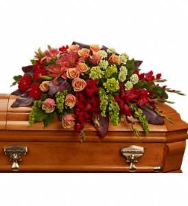 Casket spray with red, peach, and green flowers