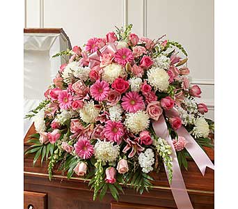 Pink and white floral casket spray with ribbon accents