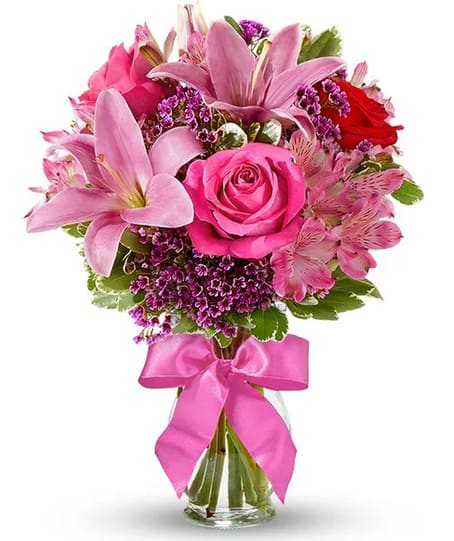 European Romance Bouquet - This flirtatious combination of Asiatic lilies, waxflower, alstroemeria and roses makes a thoughtful gift they'll not soon forget. A pretty pink ribbon and clear fluted glass vase add to the romantic look. Small Measures 13"H by 11"L. Medium Measures 14"H by 12"L. Large Measures 15"H by 13"L. Additional color varieties available. Our florists hand-design each arrangement, so colors, varieties and container may vary due to local availability. Same day delivery may not be available due to time constraints. 