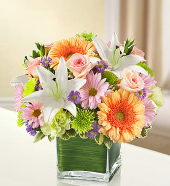 Healing Tears - Multicolor Pastel - Product ID: 95432  Express your sympathy and compassion perfectly with this beautiful multicolored arrangement of pastel blooms such as roses, Gerberas, lilies, carnations and more. A comforting tribute for the home or memorial service. Elegant pastel-toned arrangement of roses, Gerbera daisies, lilies, carnations, monte casino and poms, accented with variegated pittosporum and myrtle Artistically designed by our florists in a classic clear glass cube vase lined with a Ti leaf ribbon; vase measures 5"H x 5"D Appropriate for the service or for sending to the home or office of friends and family members Large arrangement measures approximately 11"H x 11"L Medium arrangement measures approximately 10"H x 10"L Small arrangement does not include roses and measures approximately 9"H x 9"L Our florists hand-design each arrangement, so colors, varieties, and container may vary due to local availability Lilies may arrive in bud form and will open to full beauty over the next 2-3 days