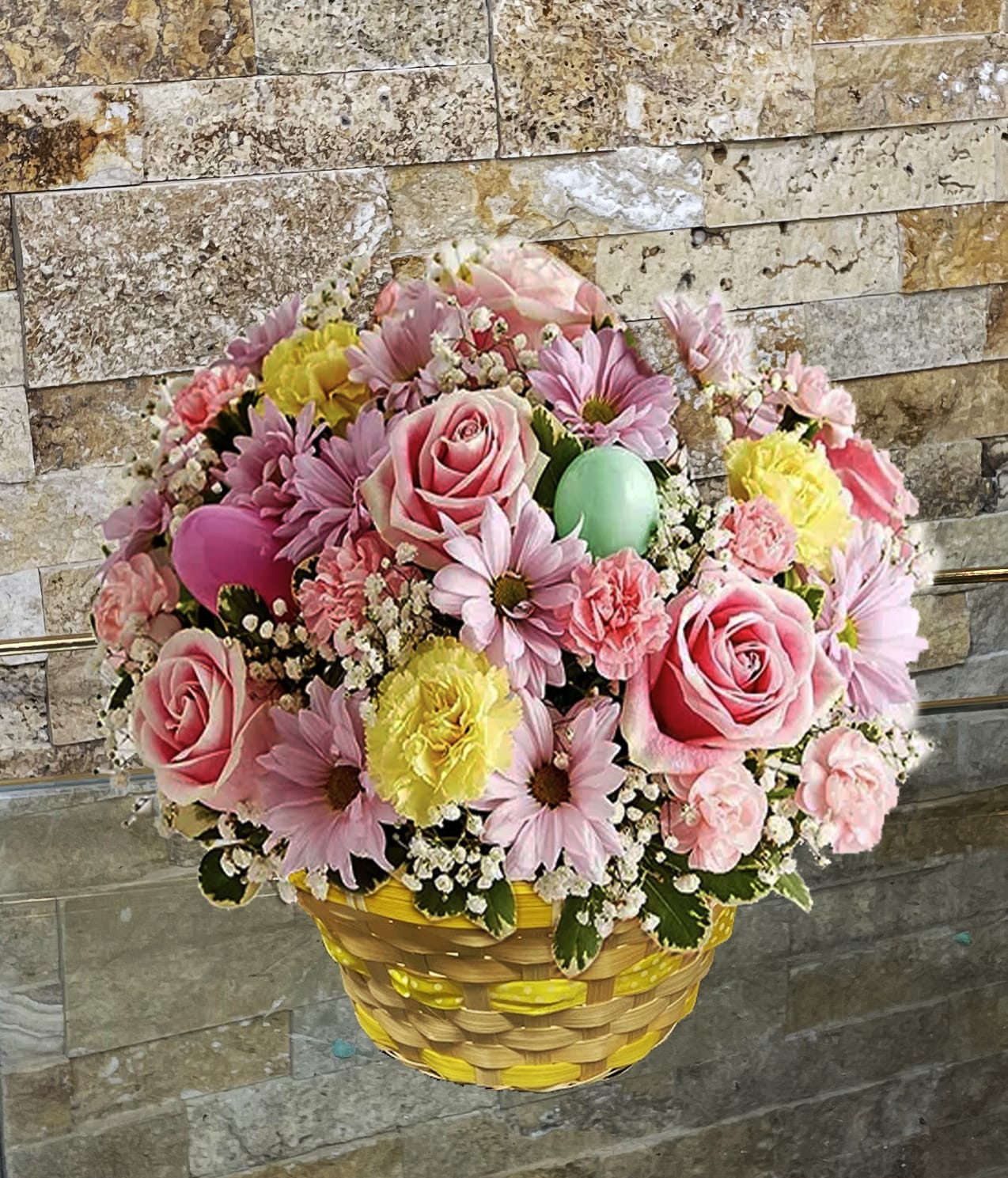 Basket arrangement of pink roses, daisies, and carnations with pastel eggs