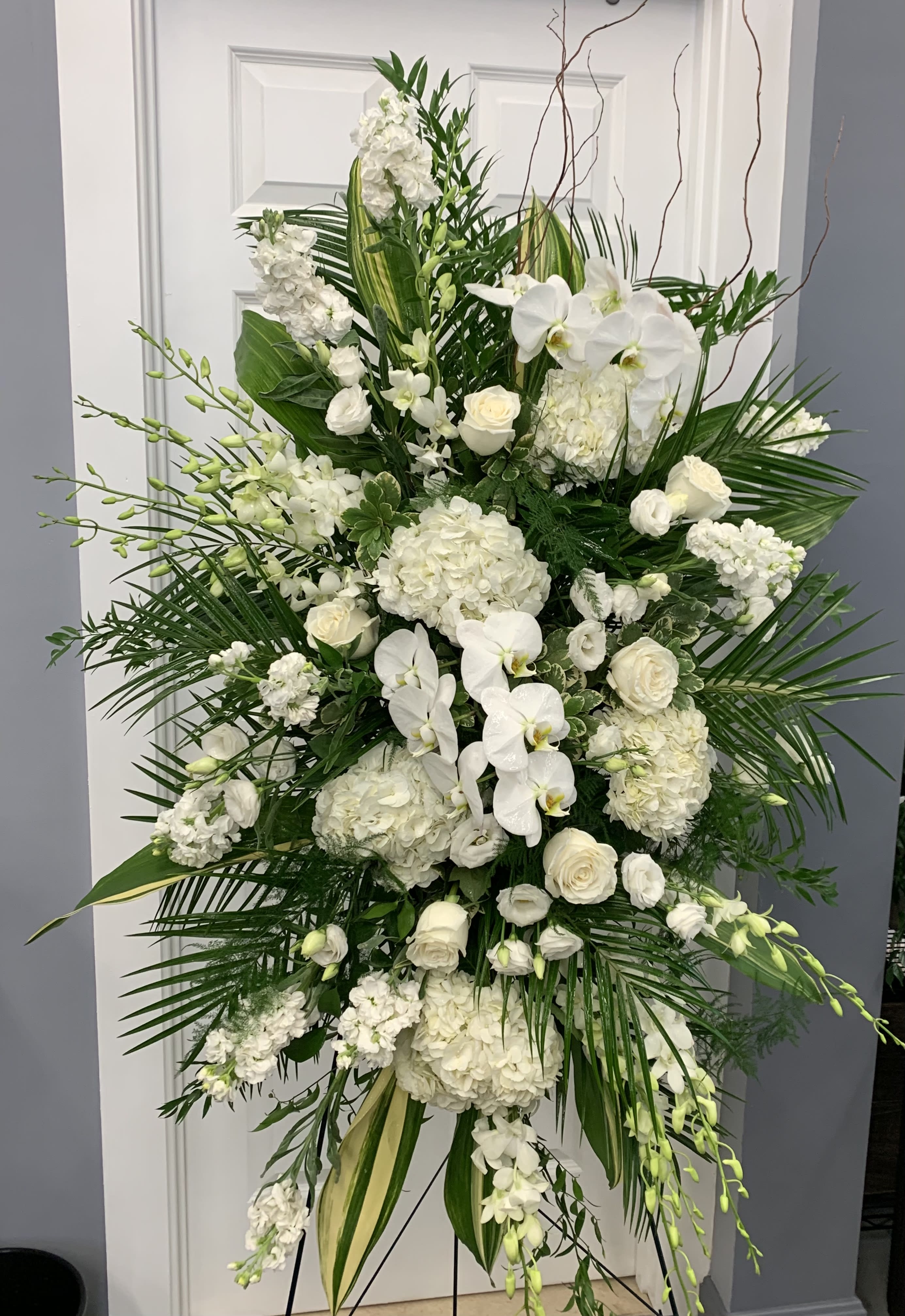 White Easel - Lovely white flowers accented with greenery placed on an easel