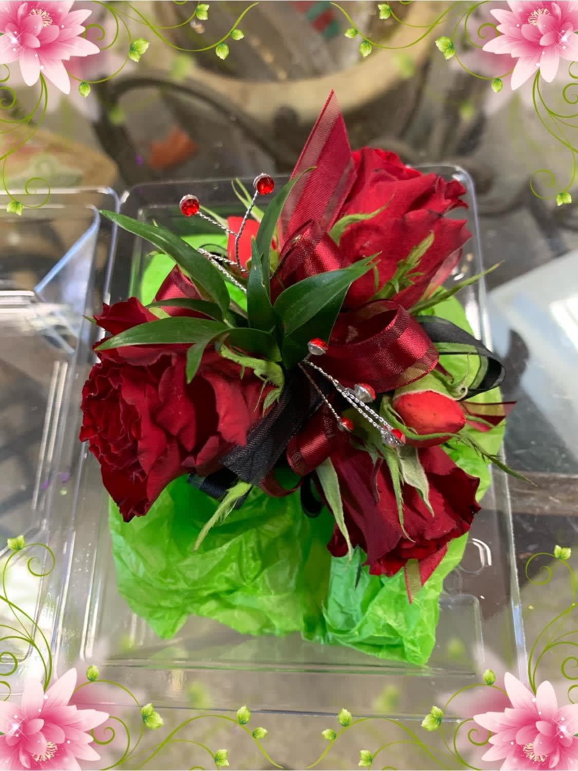 Red rose bouquet with green wrap and ribbon in a clear box