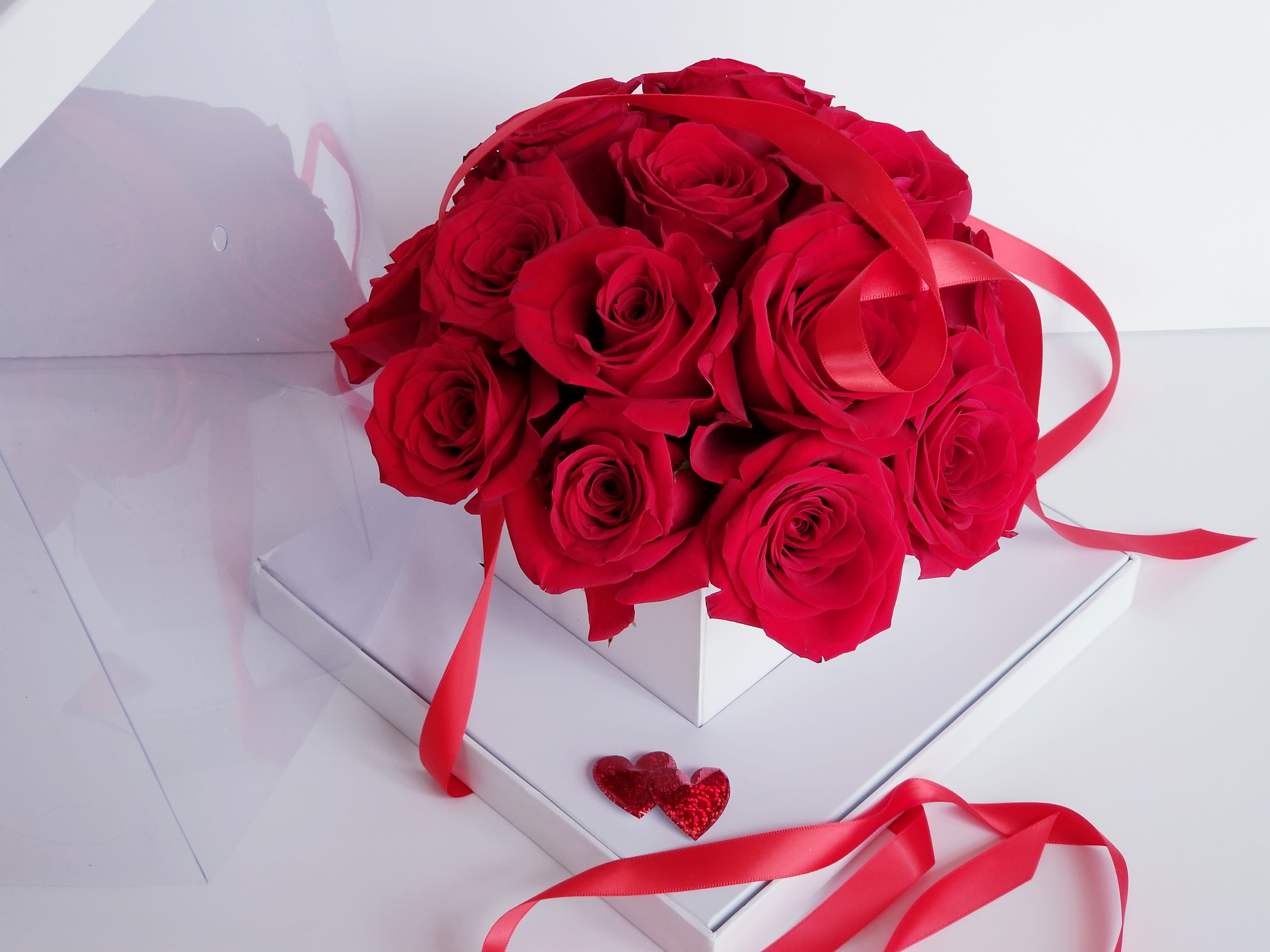 Bouquet of red roses with red ribbon in a white box