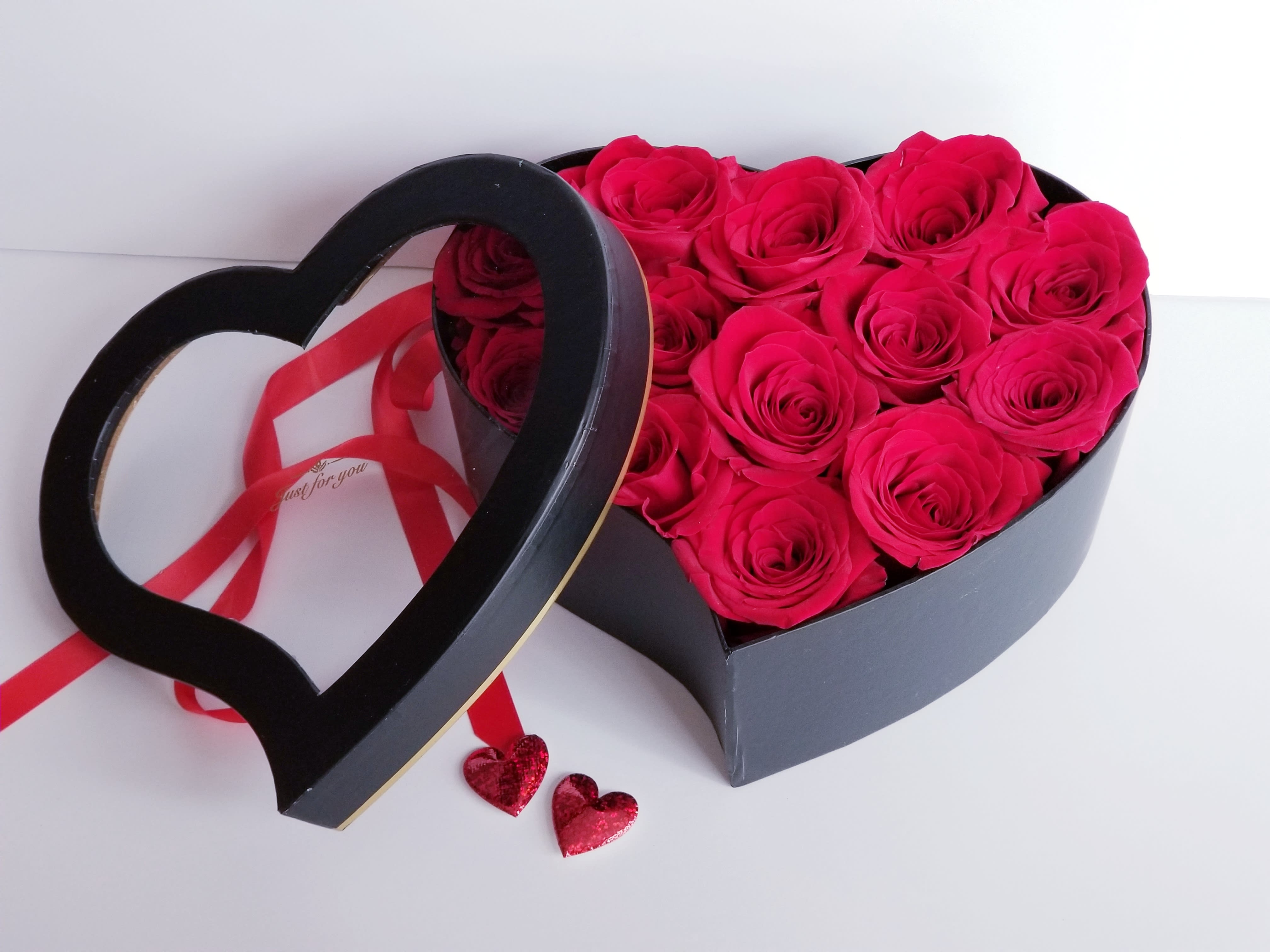 Heart-shaped box of hot pink roses with a ribbon and heart decorations