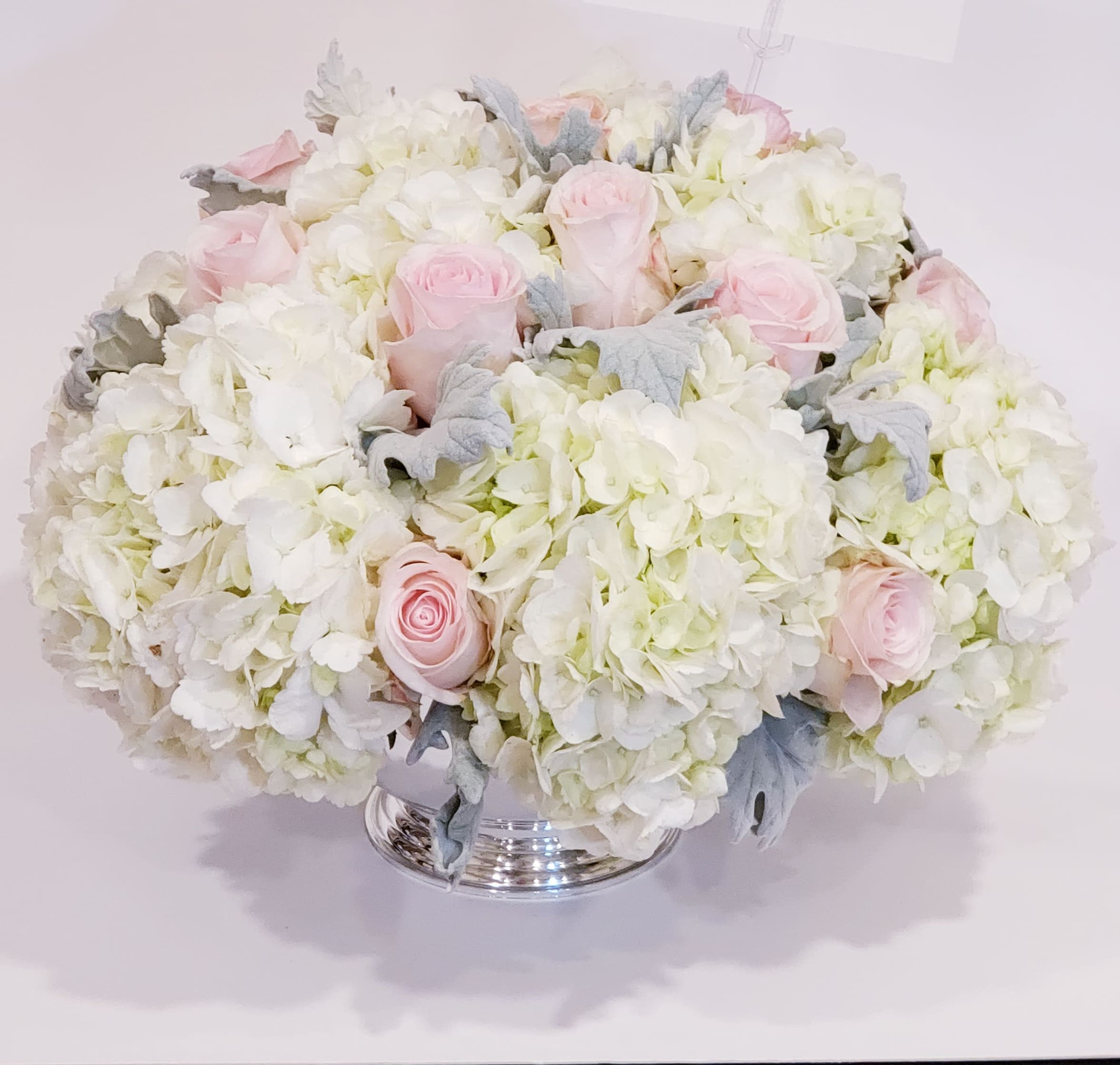 Pink roses and white hydrangeas in a silver vase