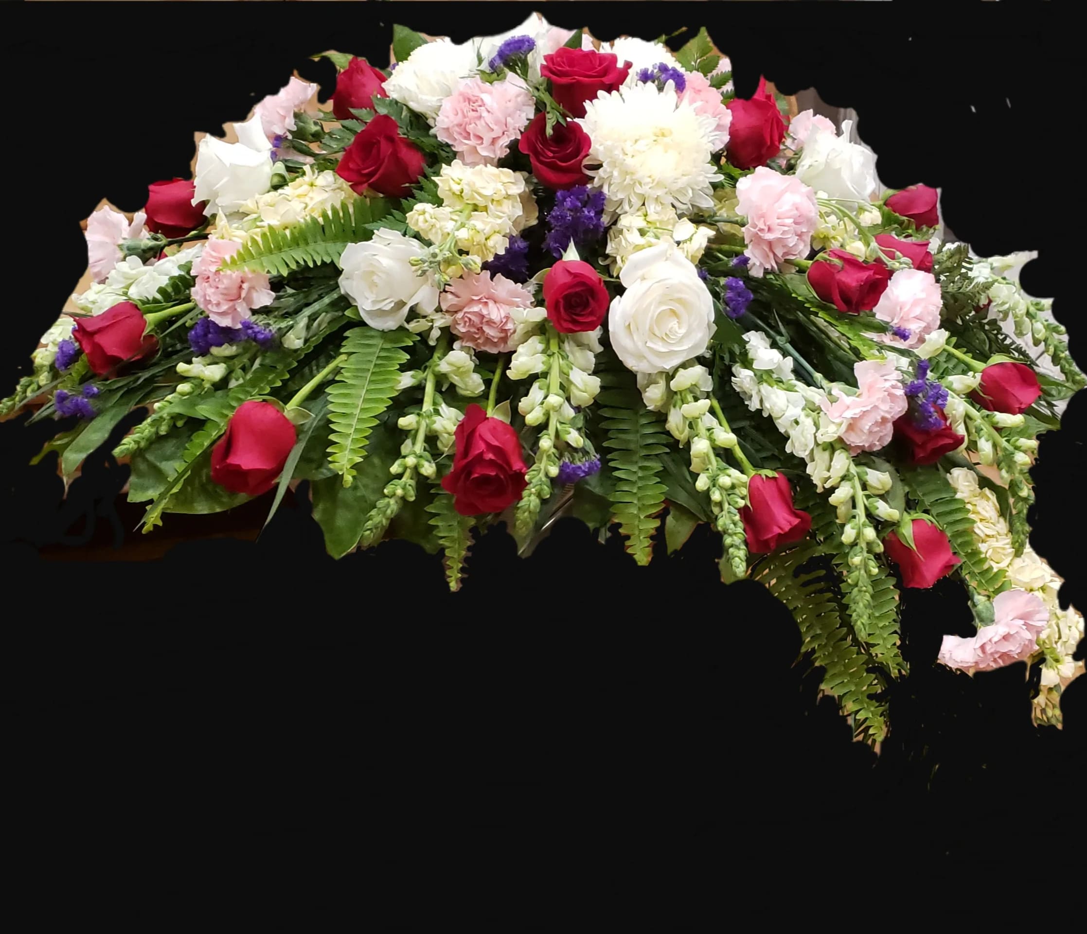 Casket spray with red and white roses, pink carnations, and greenery