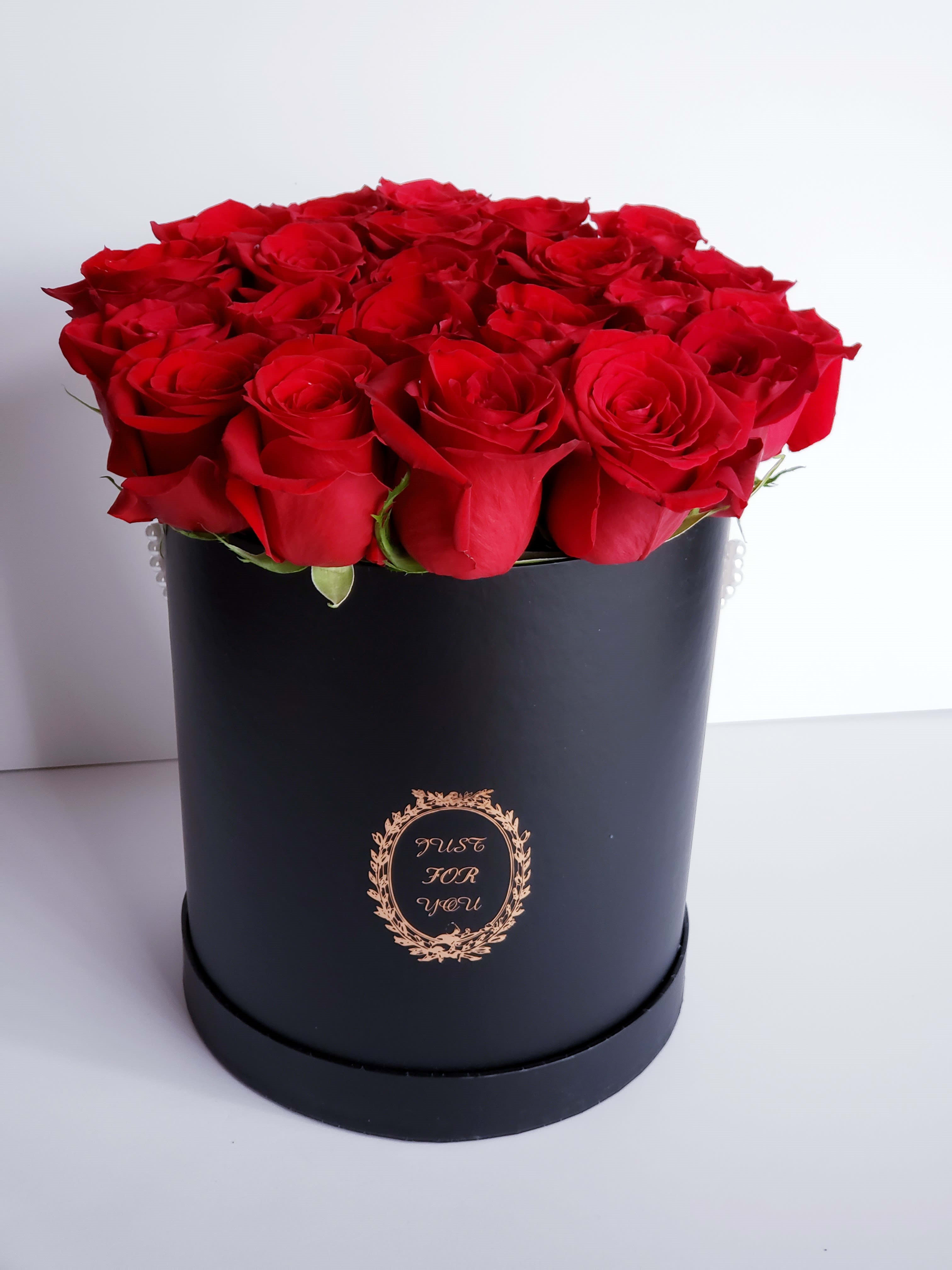 Red roses arranged in a black round box