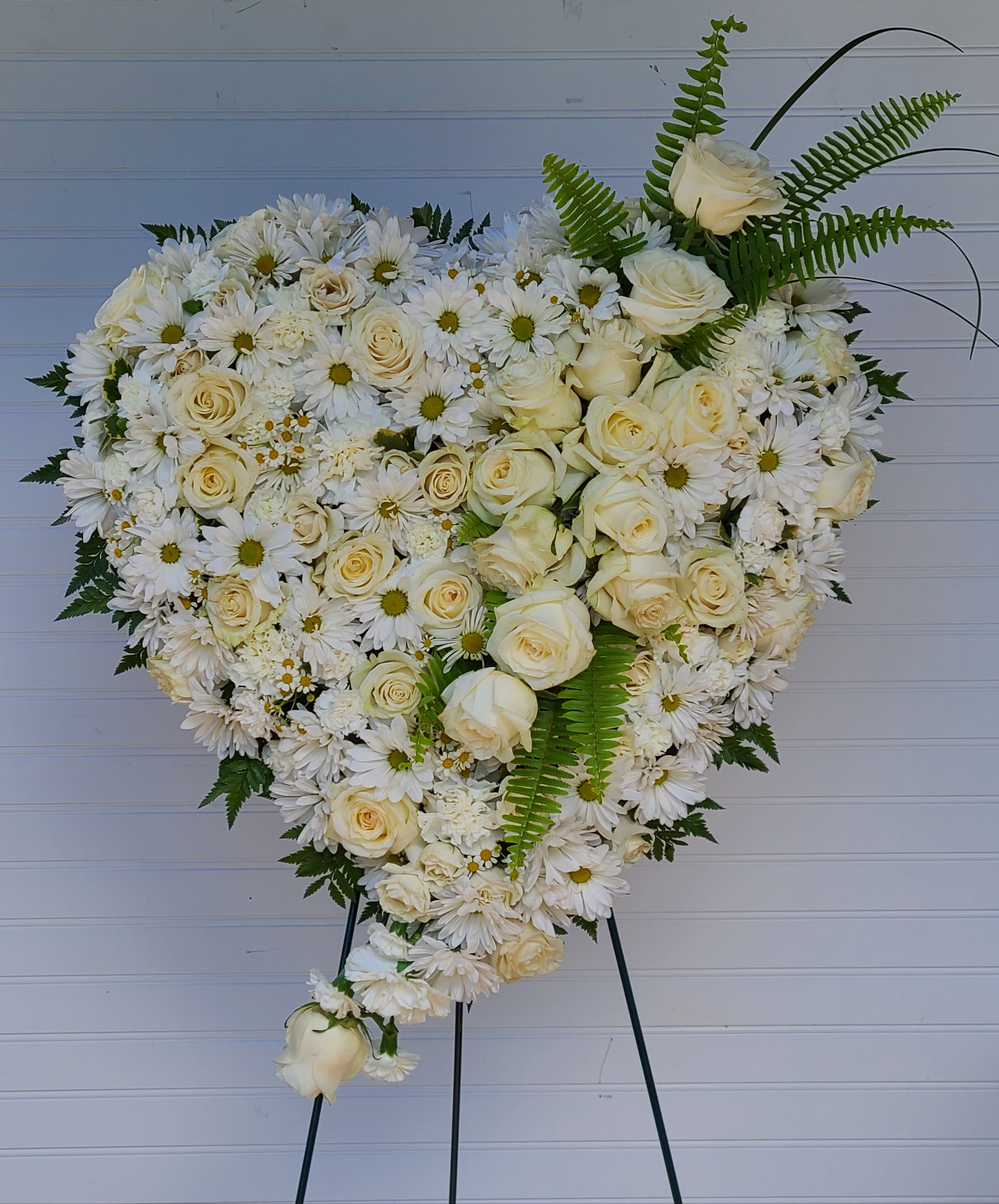 Heart-shaped white floral spray on an easel