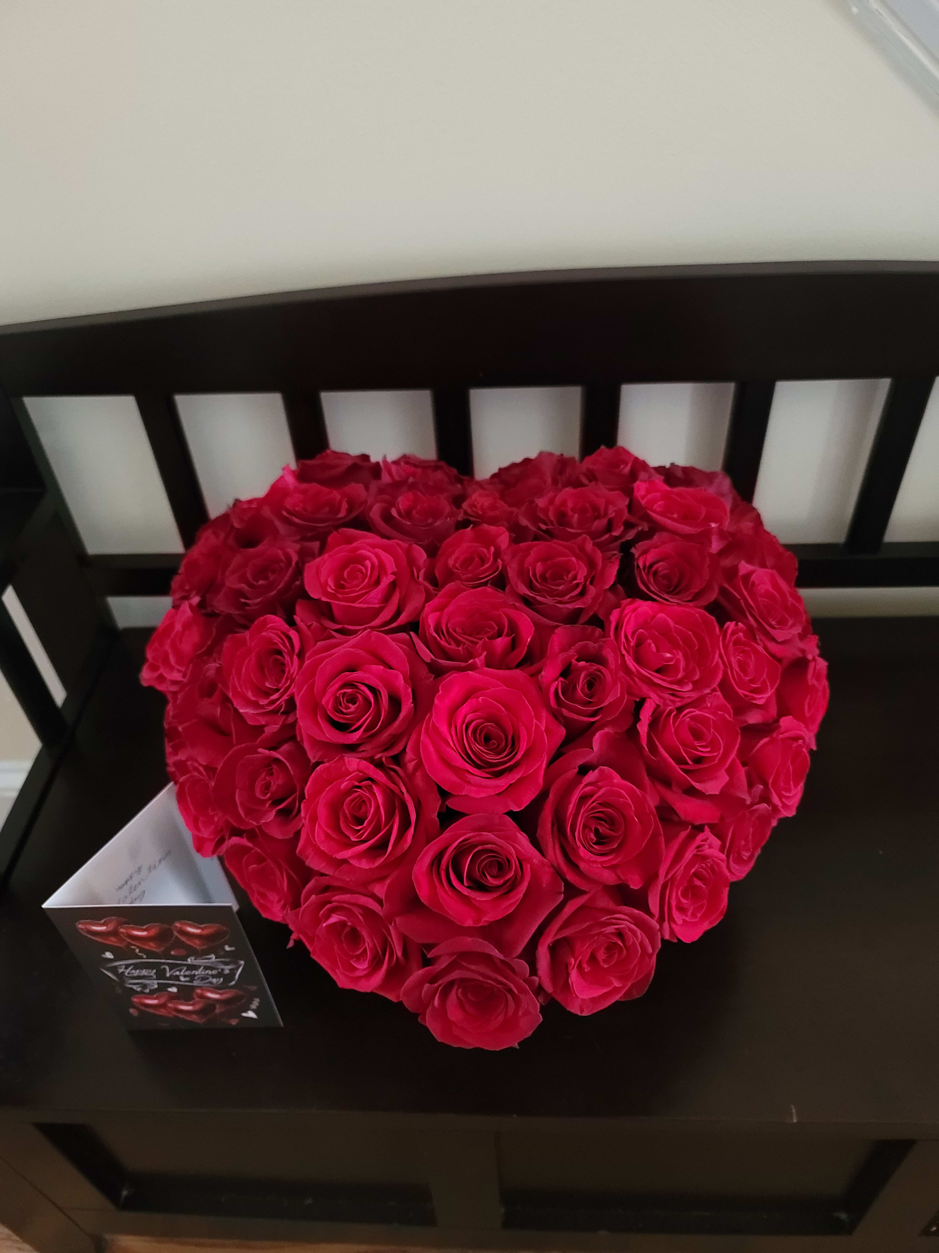 Heart-shaped bouquet of red roses on a black chair