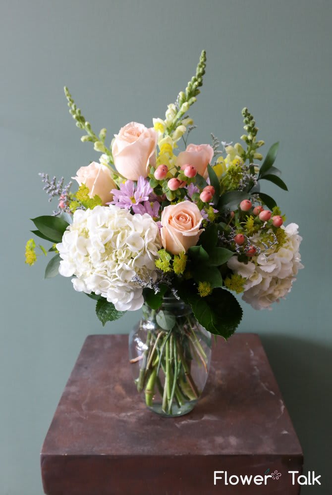 Pastel Day - Peach-toned roses, white hydrangeas, lavender stock, hypericum - A blissful blend of pastel tones including lovely lavenders, complimenting peaches with classic white accents. 