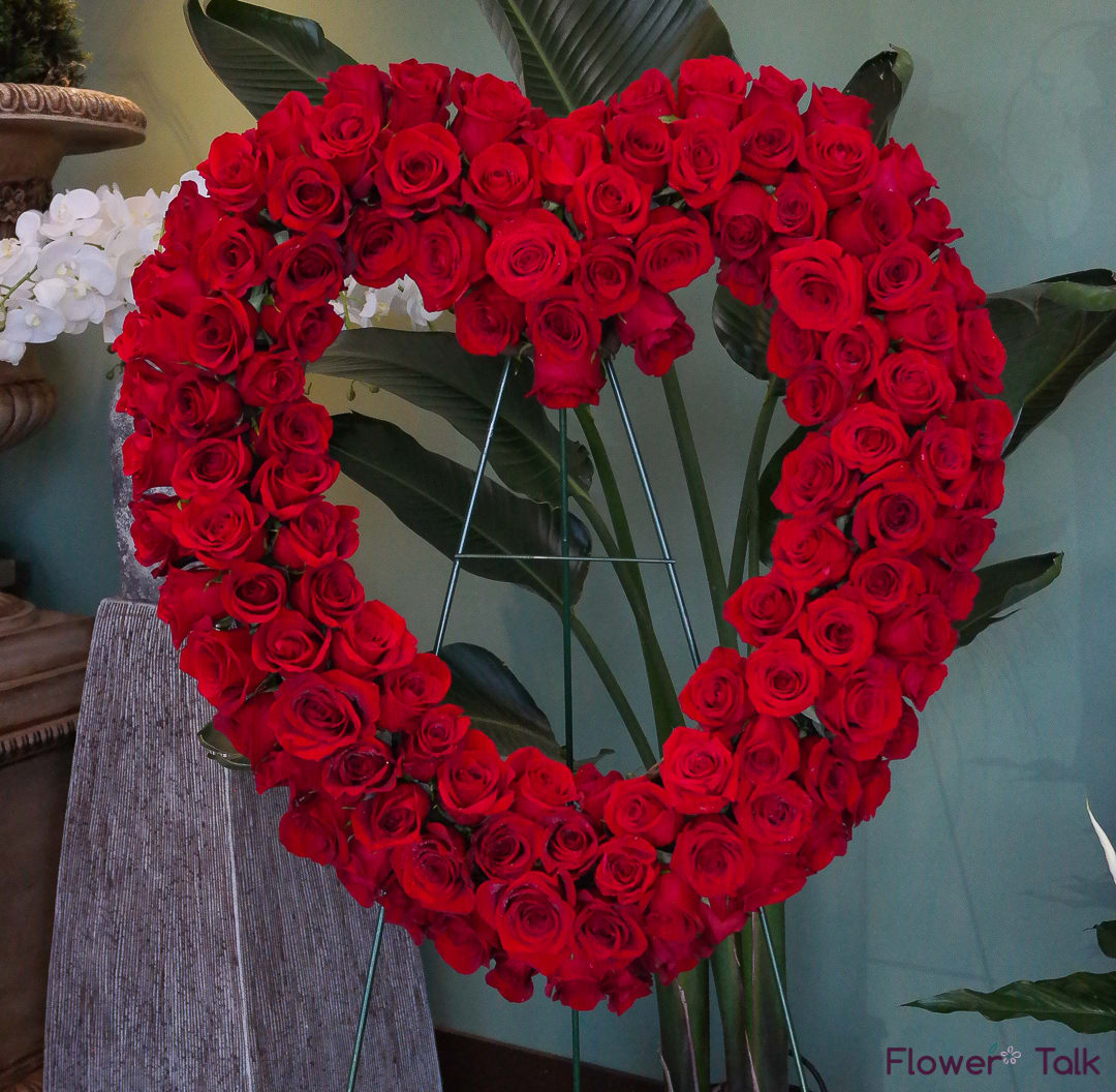 Heart-shaped arrangement of red roses on a stand