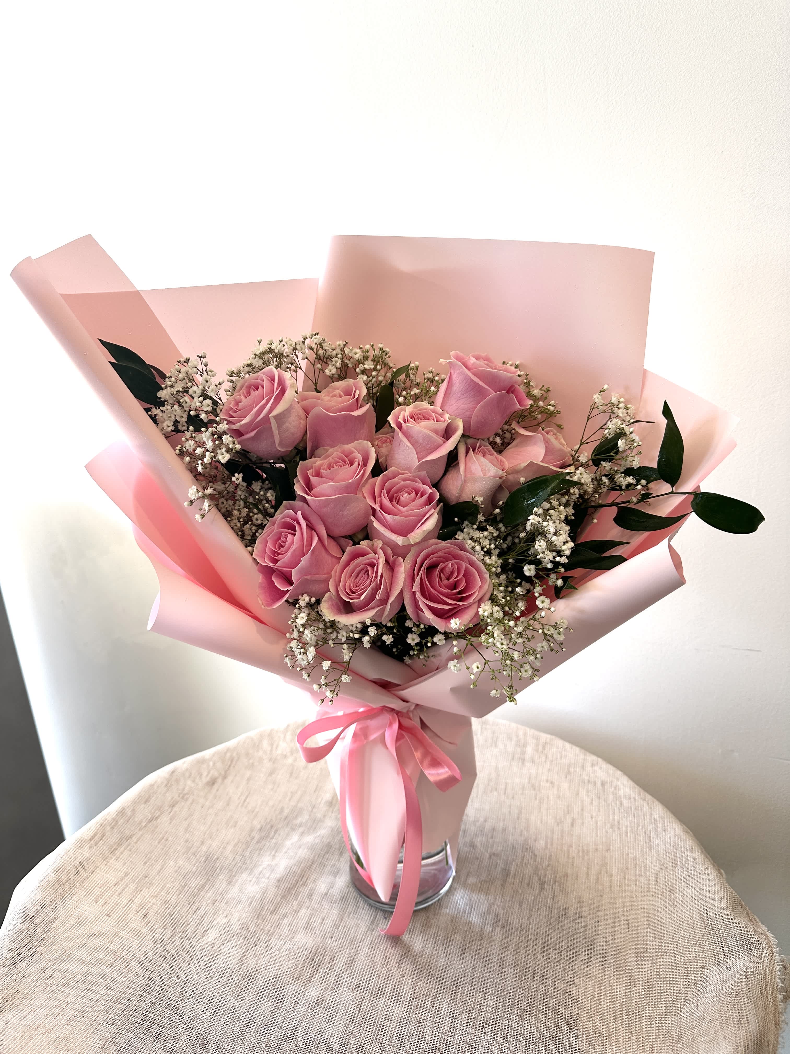 One Dozen Pink Roses Hand Bouquet (Vase not included) - 12 pink roses in a hand bouquet.  Standard: 12 roses Deluxe: 18 roses Premium: 24 roses