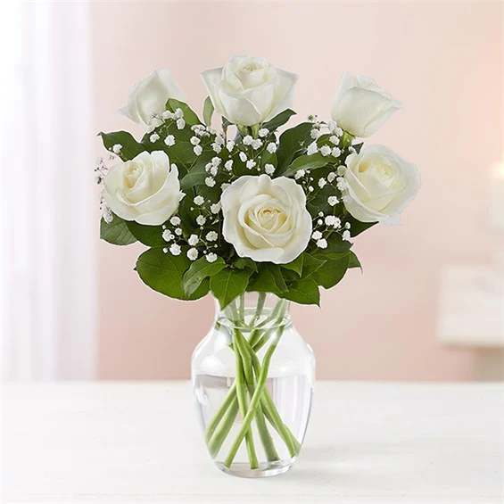 White roses arranged in a clear glass vase