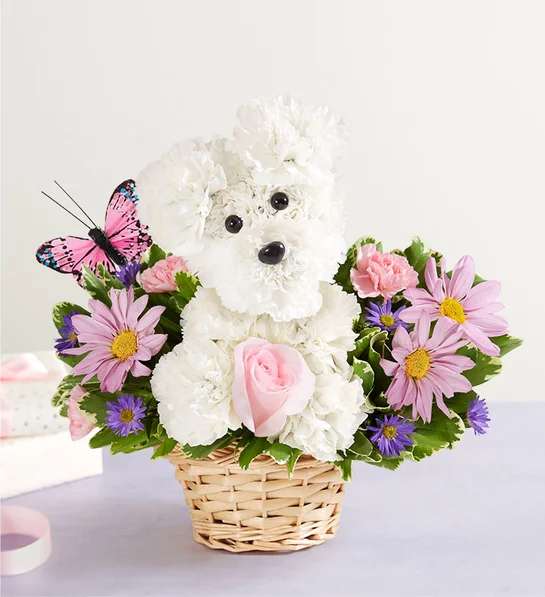 White teddy bear floral arrangement in a wicker basket with pink and purple flowers