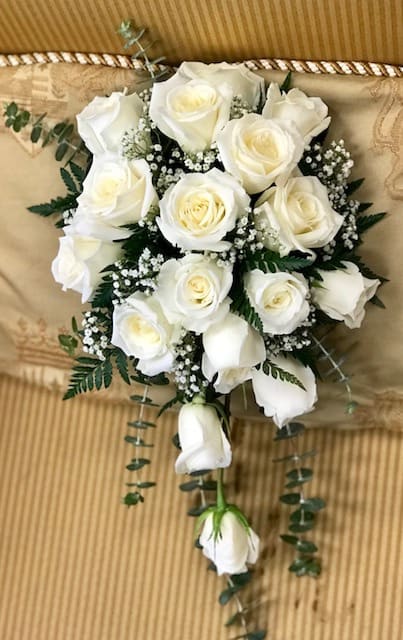 Bouquet of white roses with baby's breath and trailing greenery