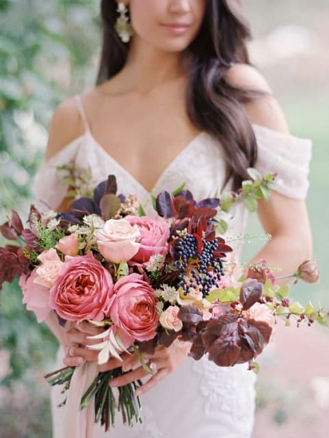 Woman holding a pink and burgundy bridal bouquet