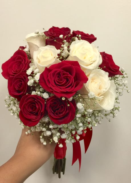 Bouquet of red and white roses with baby's breath and a red ribbon