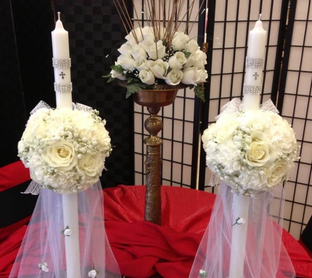 White floral wedding candles with rose arrangements and tulle