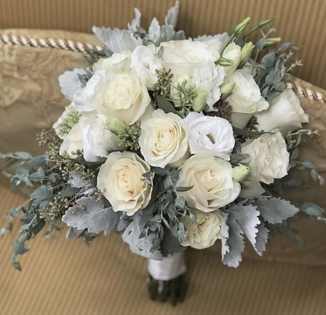 White rose bouquet with gray foliage and a wrapped handle