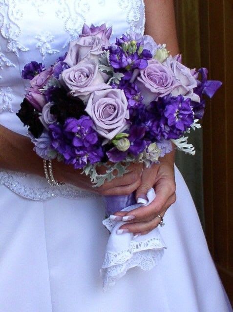 Bride holding a bouquet of lavender roses and purple flowers