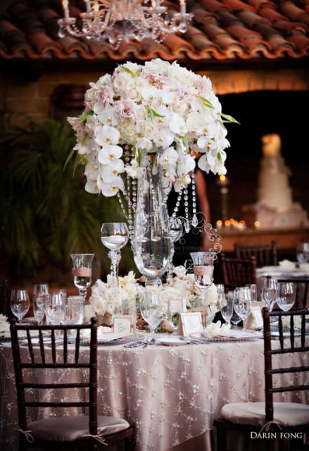 Tall white floral centerpiece on a decorated banquet table