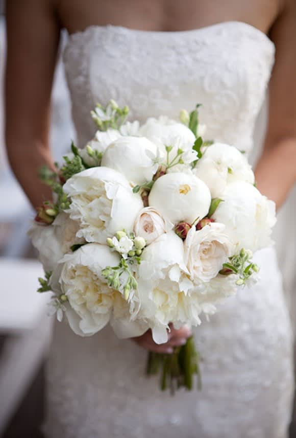 Bride holding a white bouquet of peonies and roses