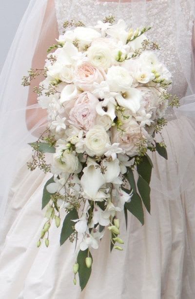 Bridal bouquet of white and blush flowers with trailing greenery