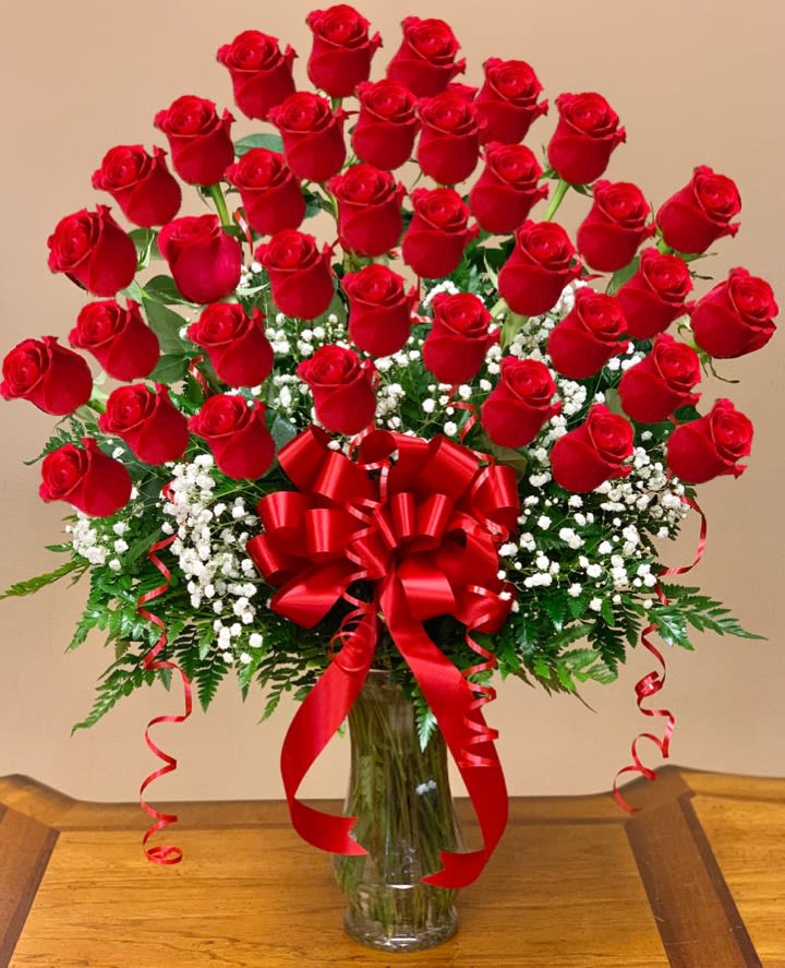 Bouquet of red roses in a glass vase with a red ribbon