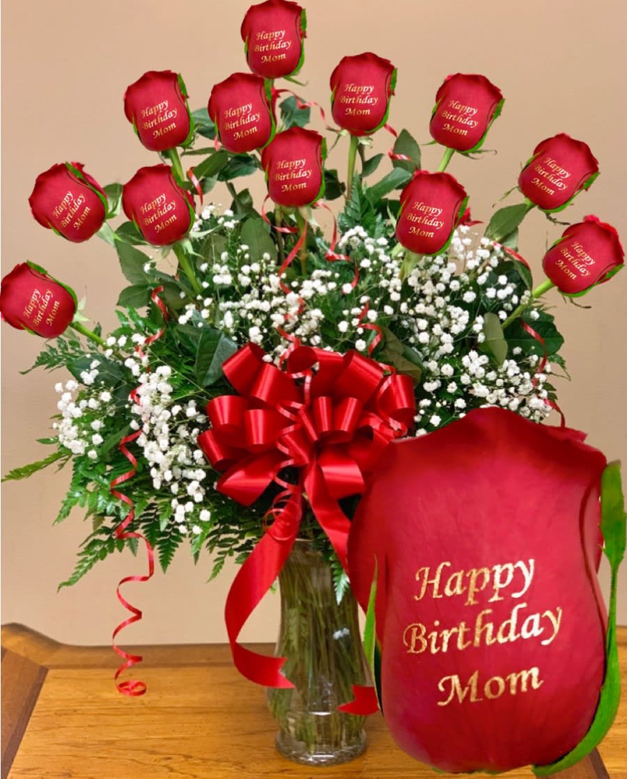 Red roses with birthday message petals in a glass vase