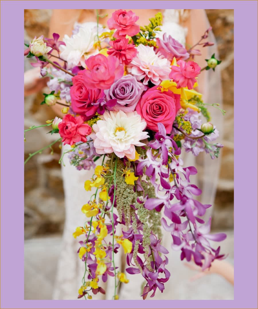 Cascade bouquet of pink, white, and purple flowers with trailing orchids