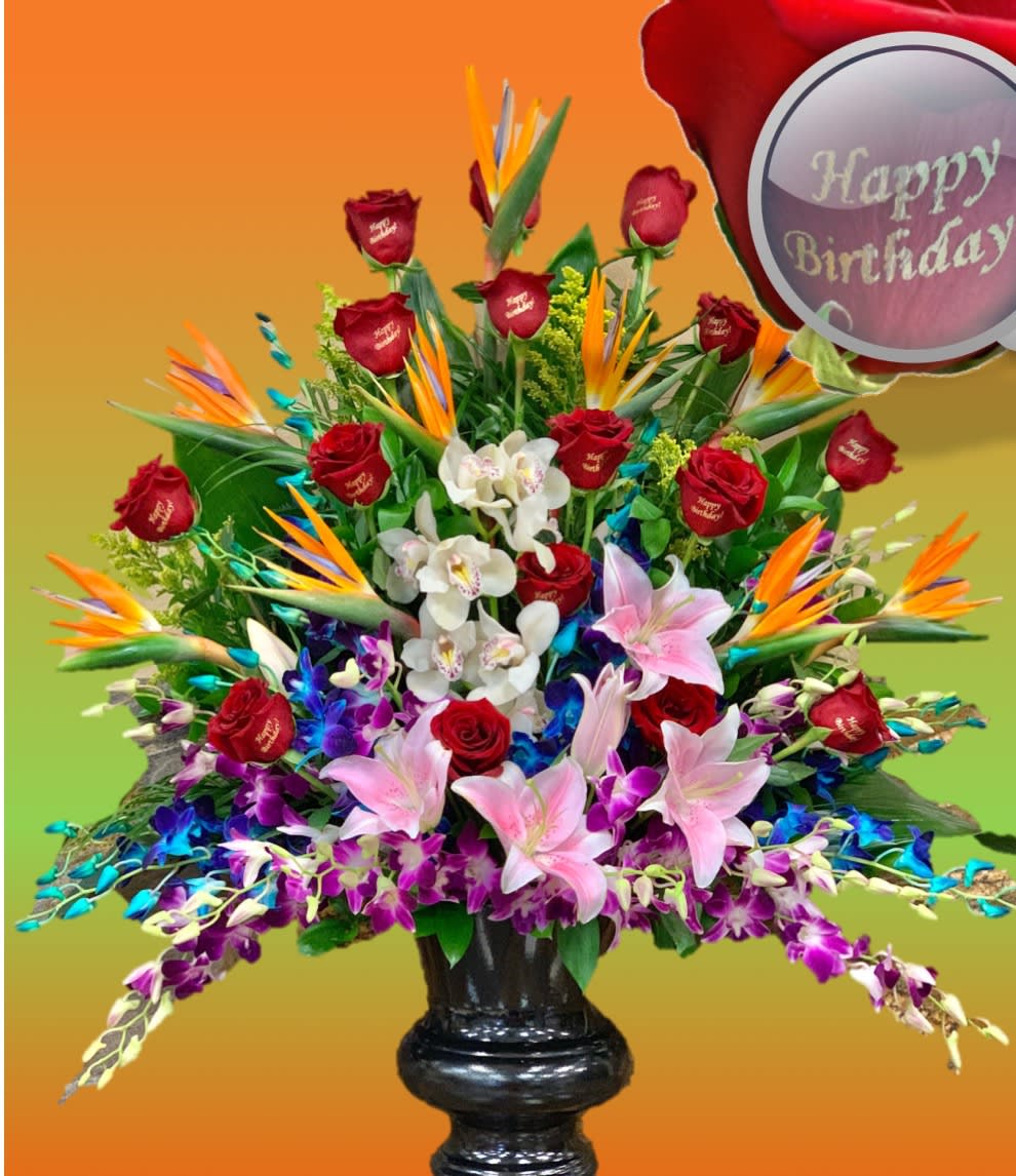 Large mixed bouquet with red roses, lilies, orchids, and bird-of-paradise in a black vase