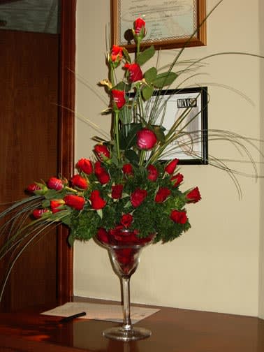 Tall red rose arrangement in a clear stemmed vase