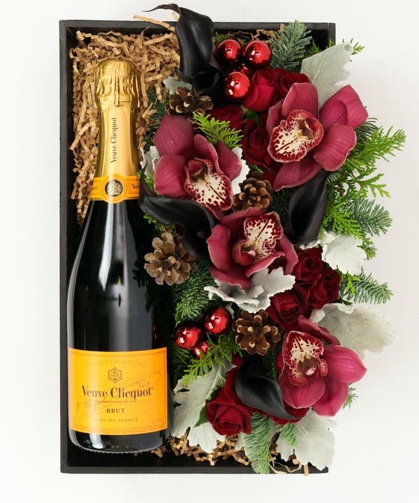 Gift box with a champagne bottle and red floral arrangement
