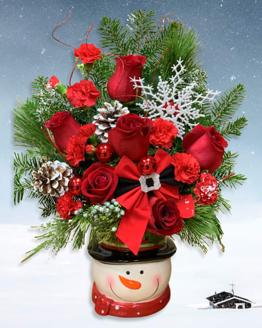 Red roses and carnations in a snowman planter with pinecones and ribbon