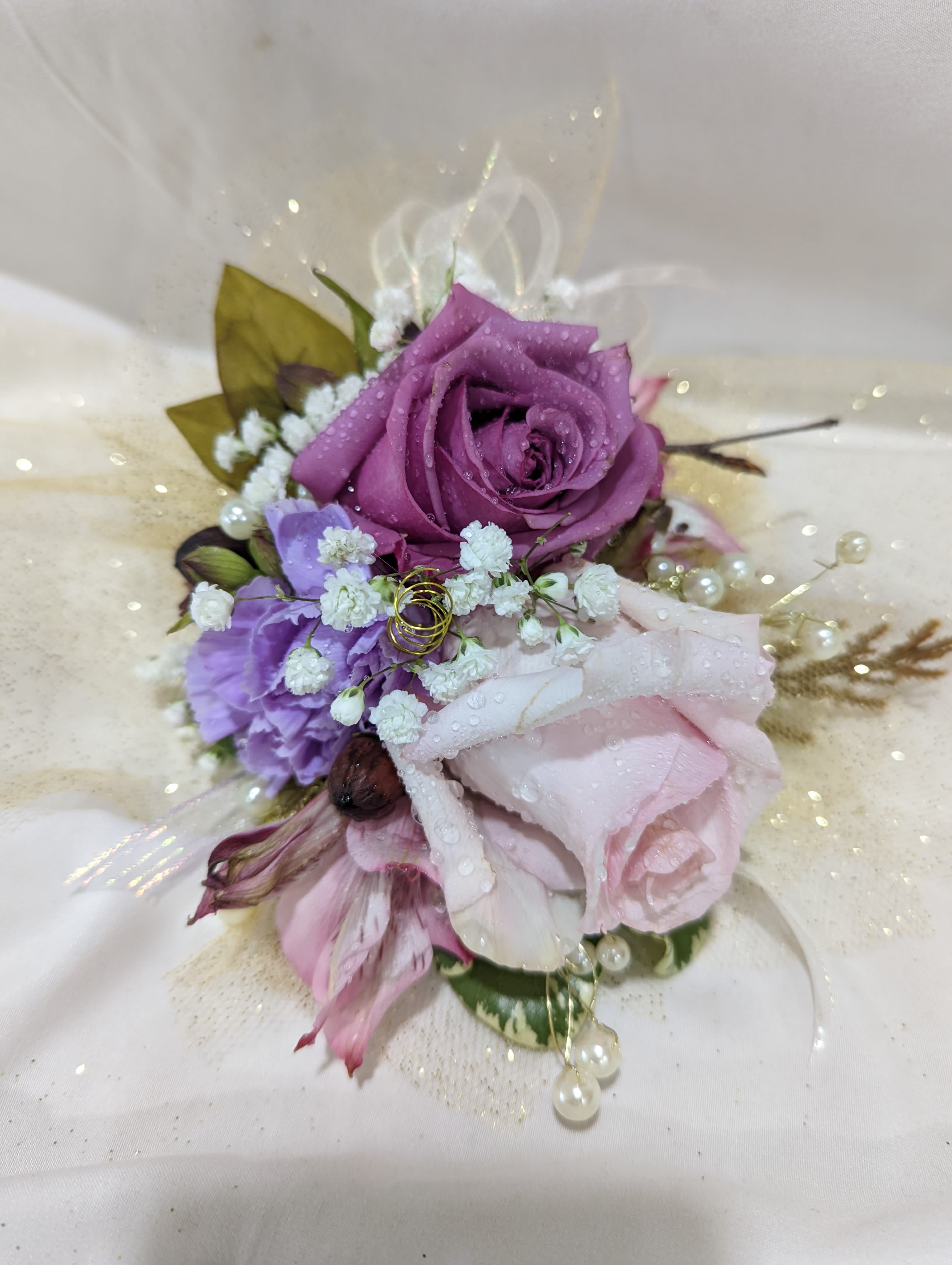 Small bouquet with purple and pink roses and baby’s breath