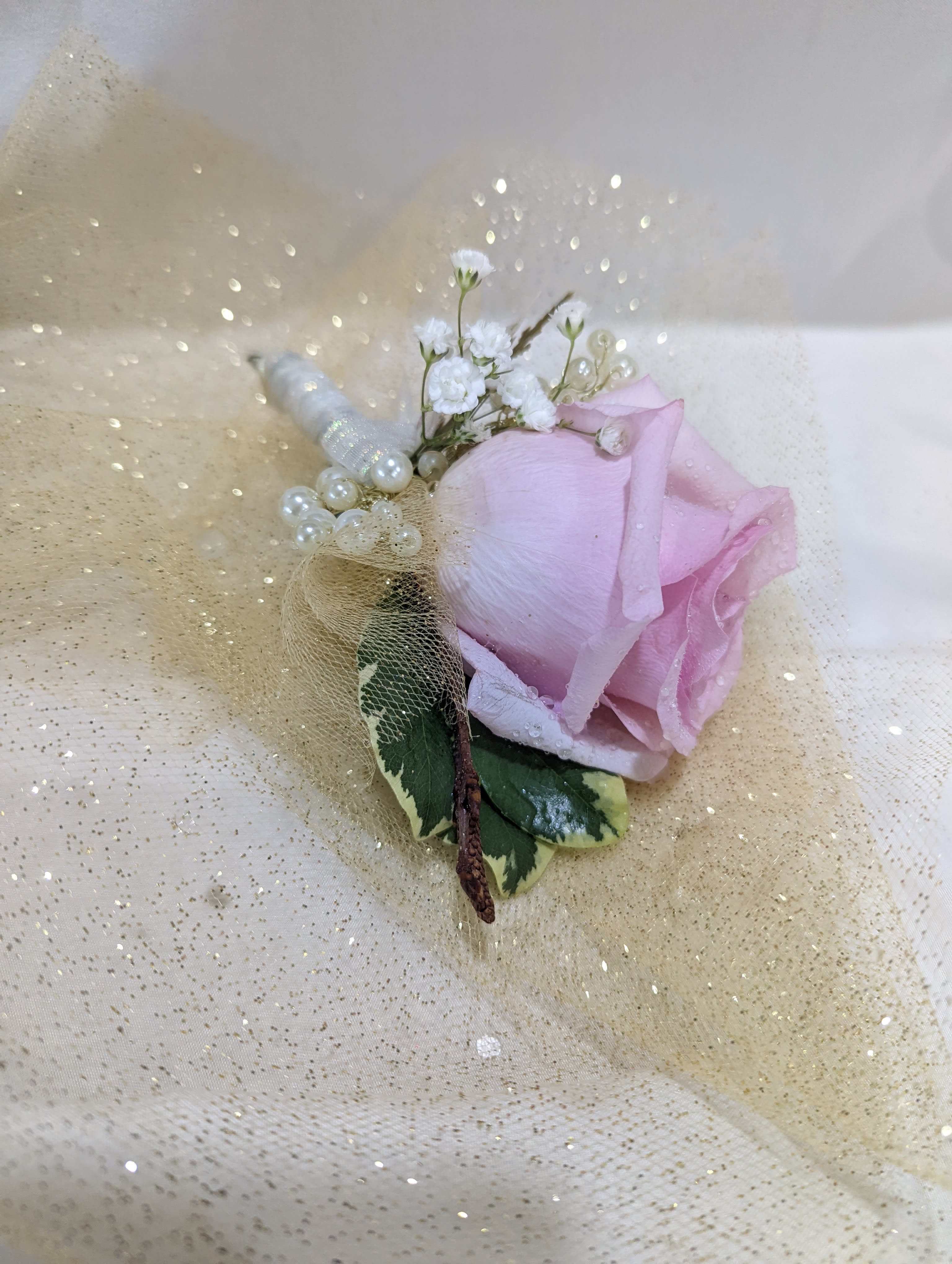 Pink rose boutonniere with pearl accents and gold tulle wrap