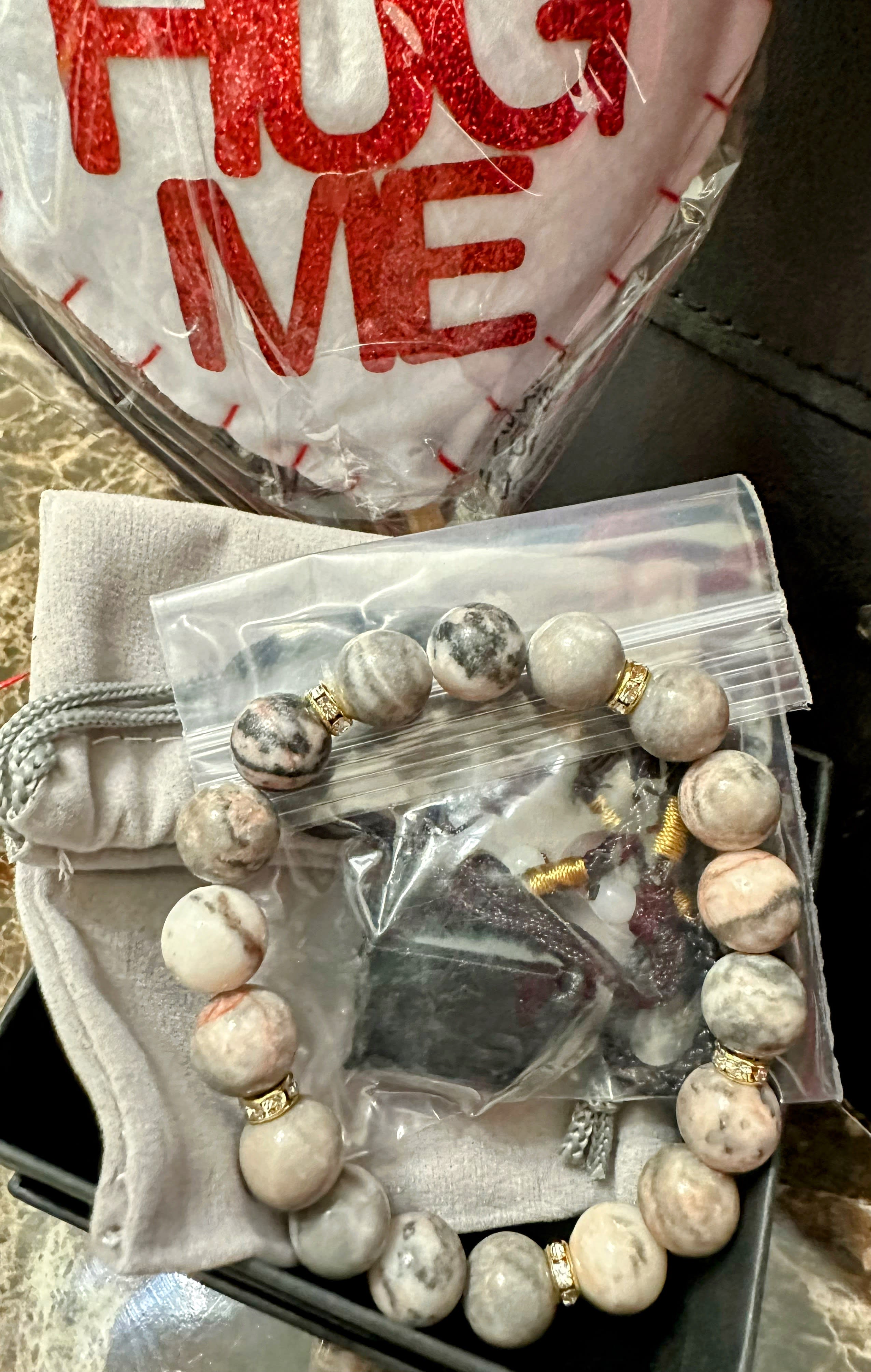 Beaded bracelet and a heart-shaped item in plastic packaging