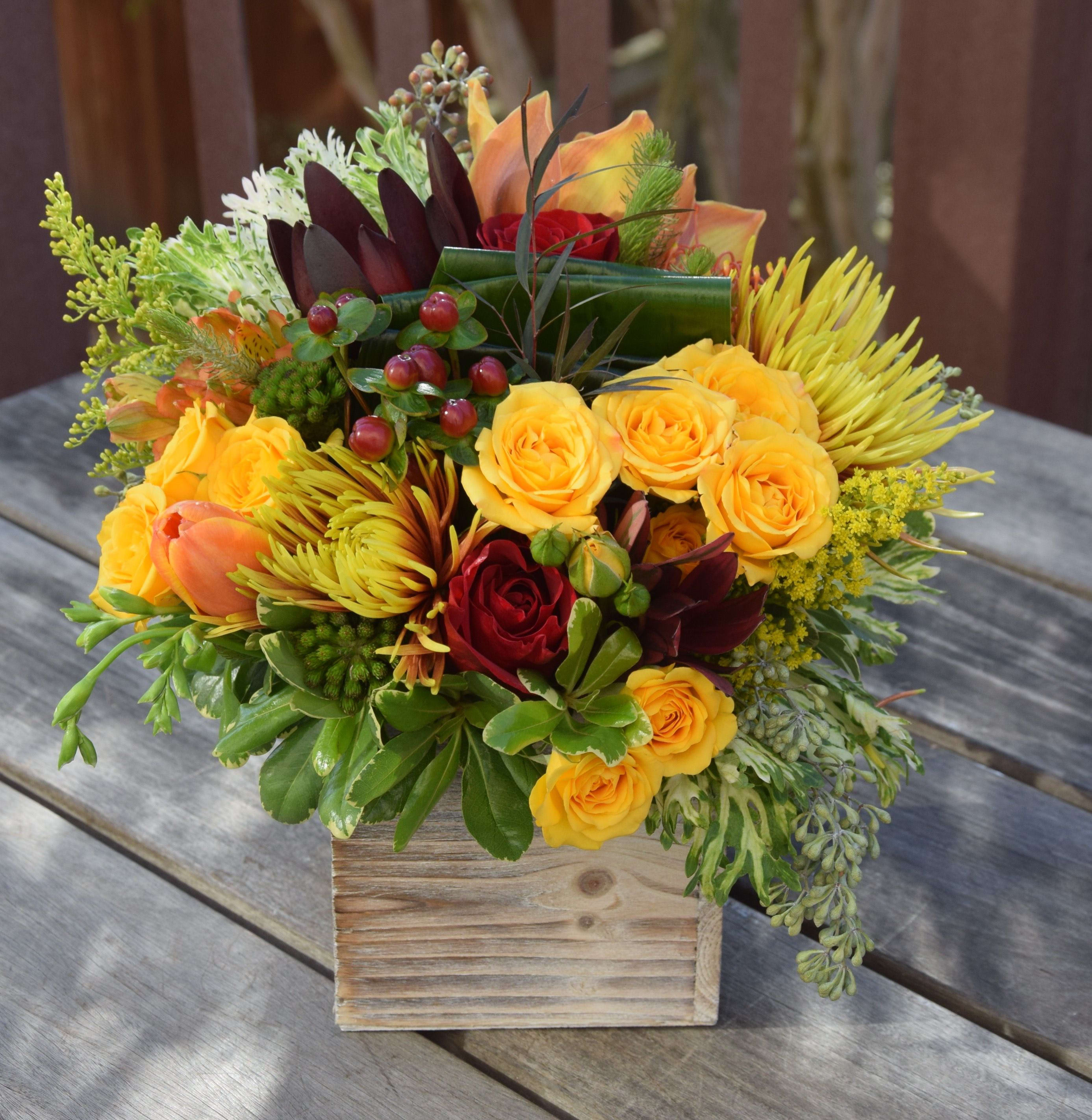 Mixed bouquet of yellow and red roses in a wooden box