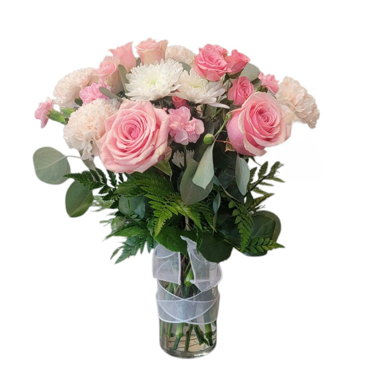 Pink roses and white flowers in a clear glass vase with ribbon
