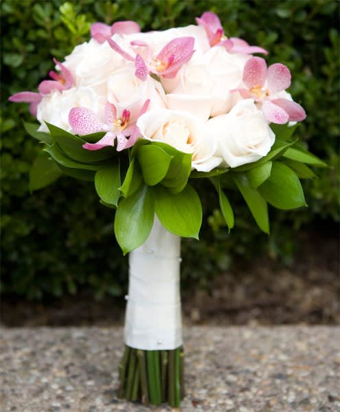 White rose bouquet with pink orchids and green leaves